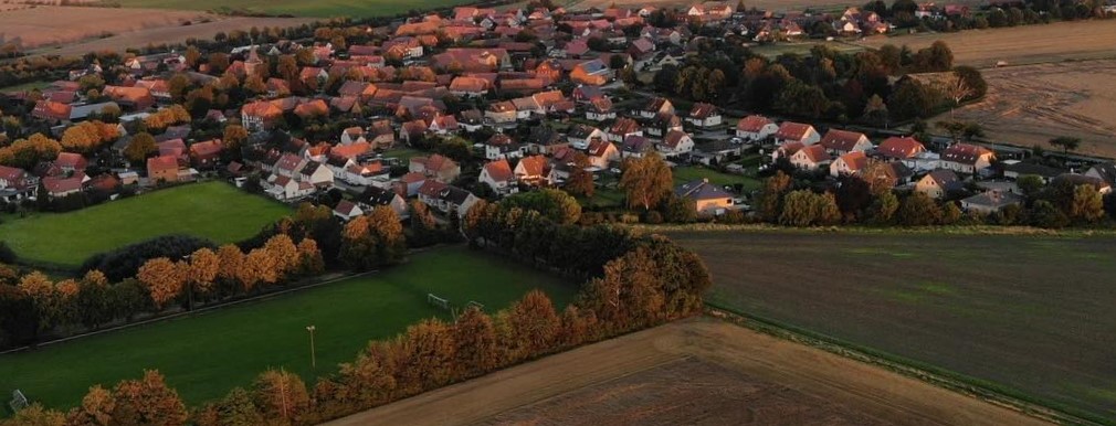 Luftbild von Lengde mit Sportplatz im Vordergrund.